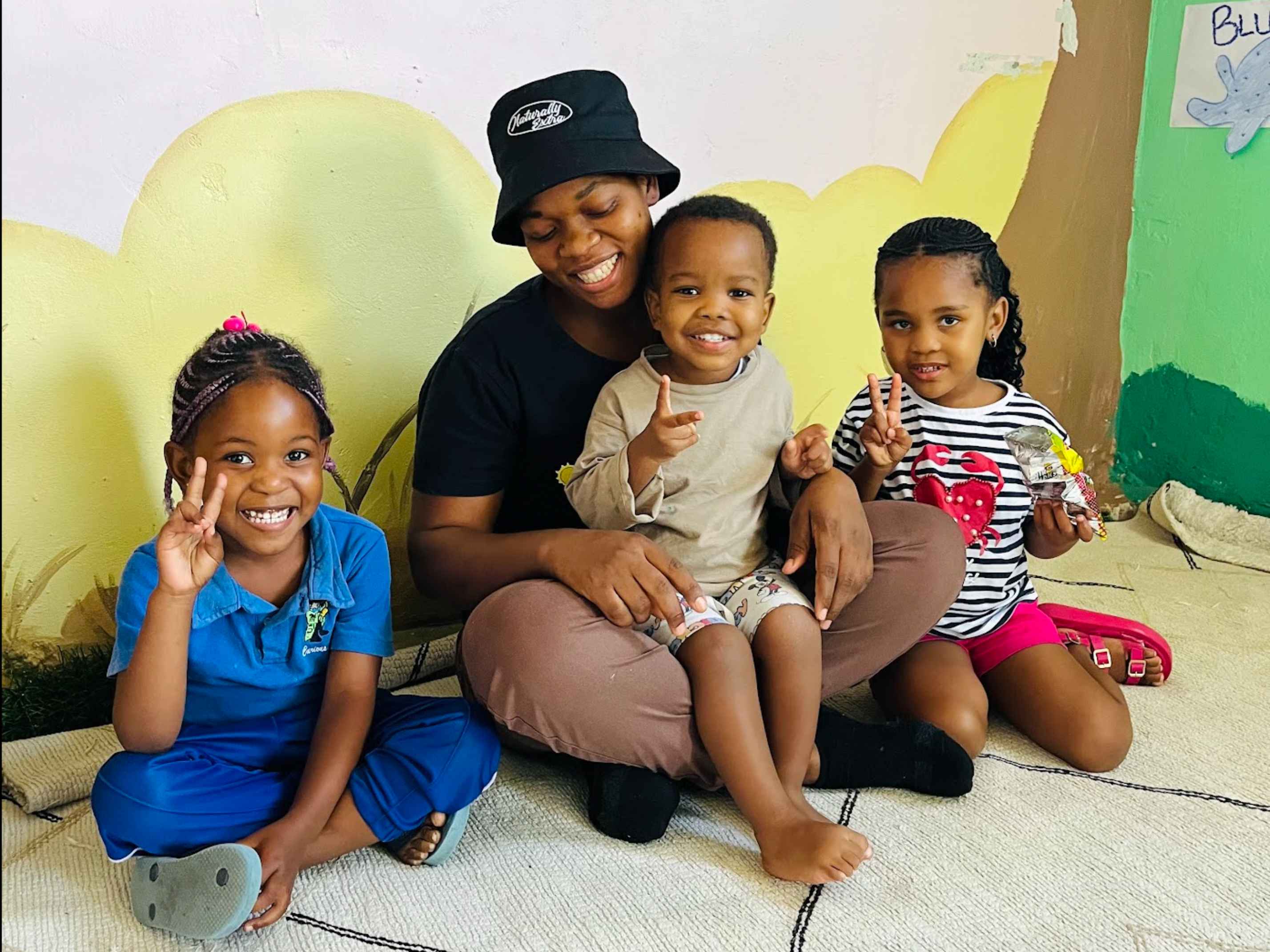 Munchkins Daycare teacher with smiling children